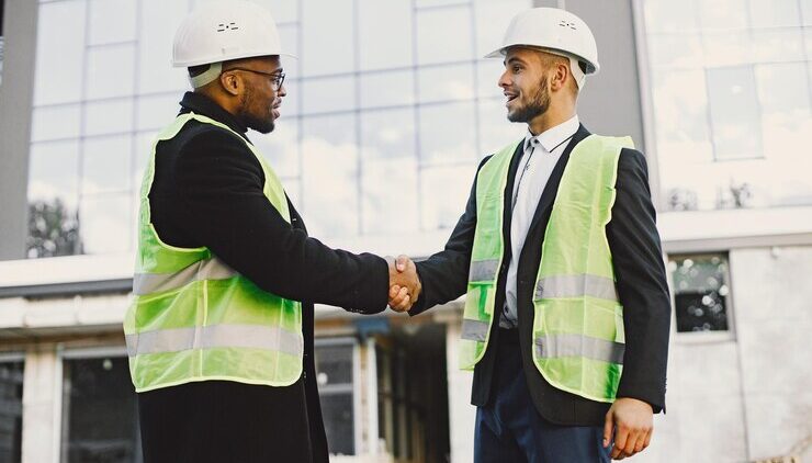 multi-racial-builders-handshaking-outdoors-wearing-uniform-talking-about-new-glass-building-working-poject-city-infrastructure_1157-50877
